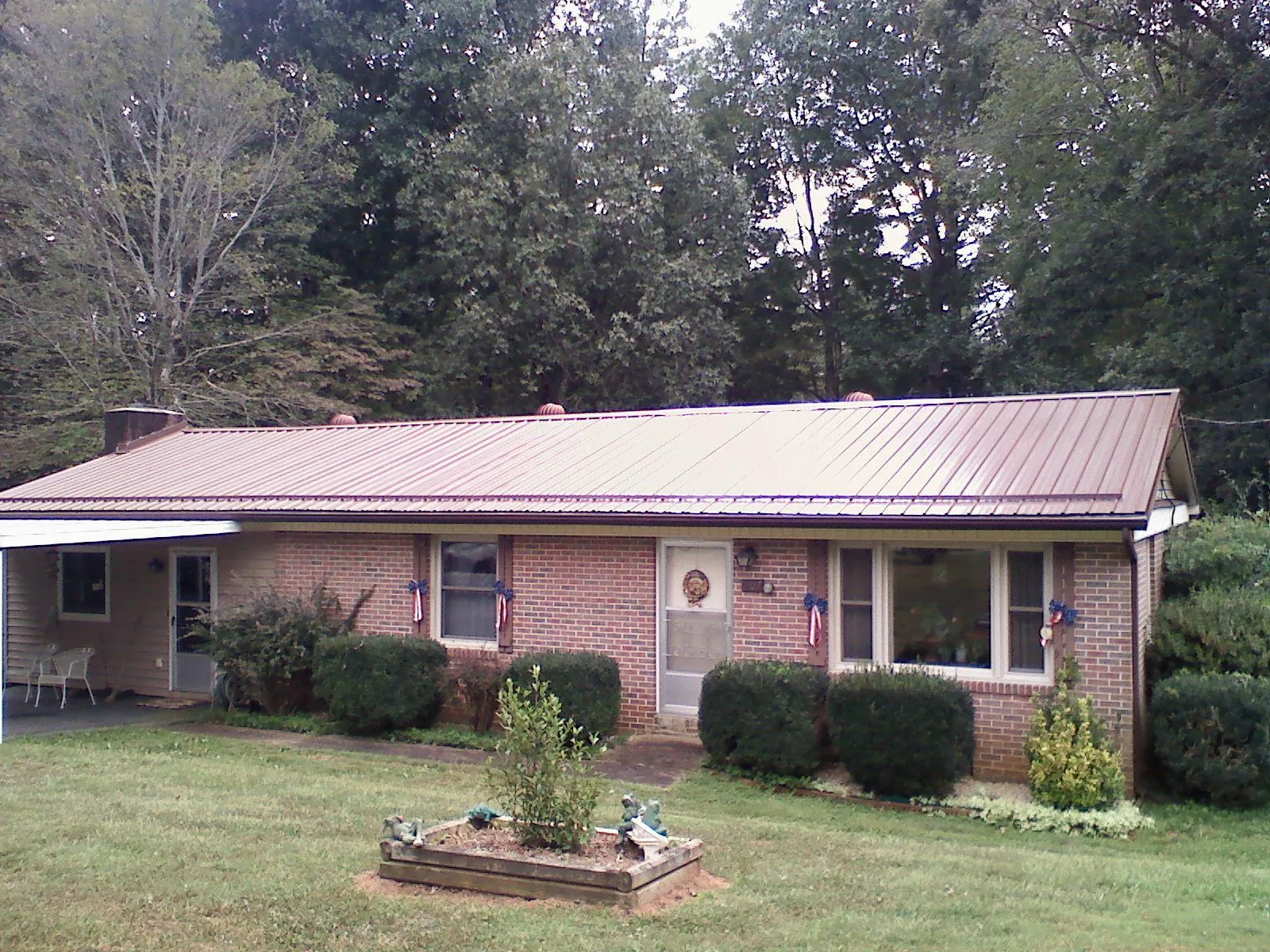 Bronze metal roof on a brick ranch home with a carport in Florence
